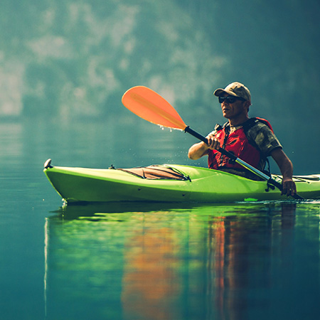 male padding in a kayak on the open water