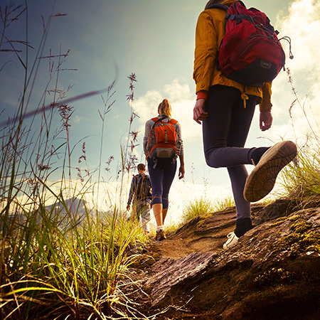 3 people trekking across the country side